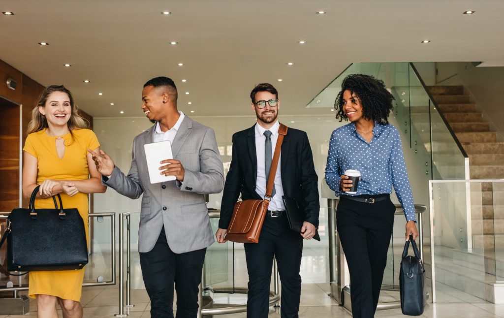 image of four employees leaving work together smiling and chatting